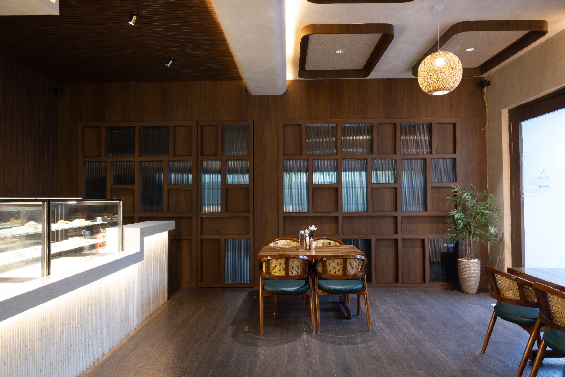 D'Scops Café dessert counter, wooden wall, table seating, and warm café interiors